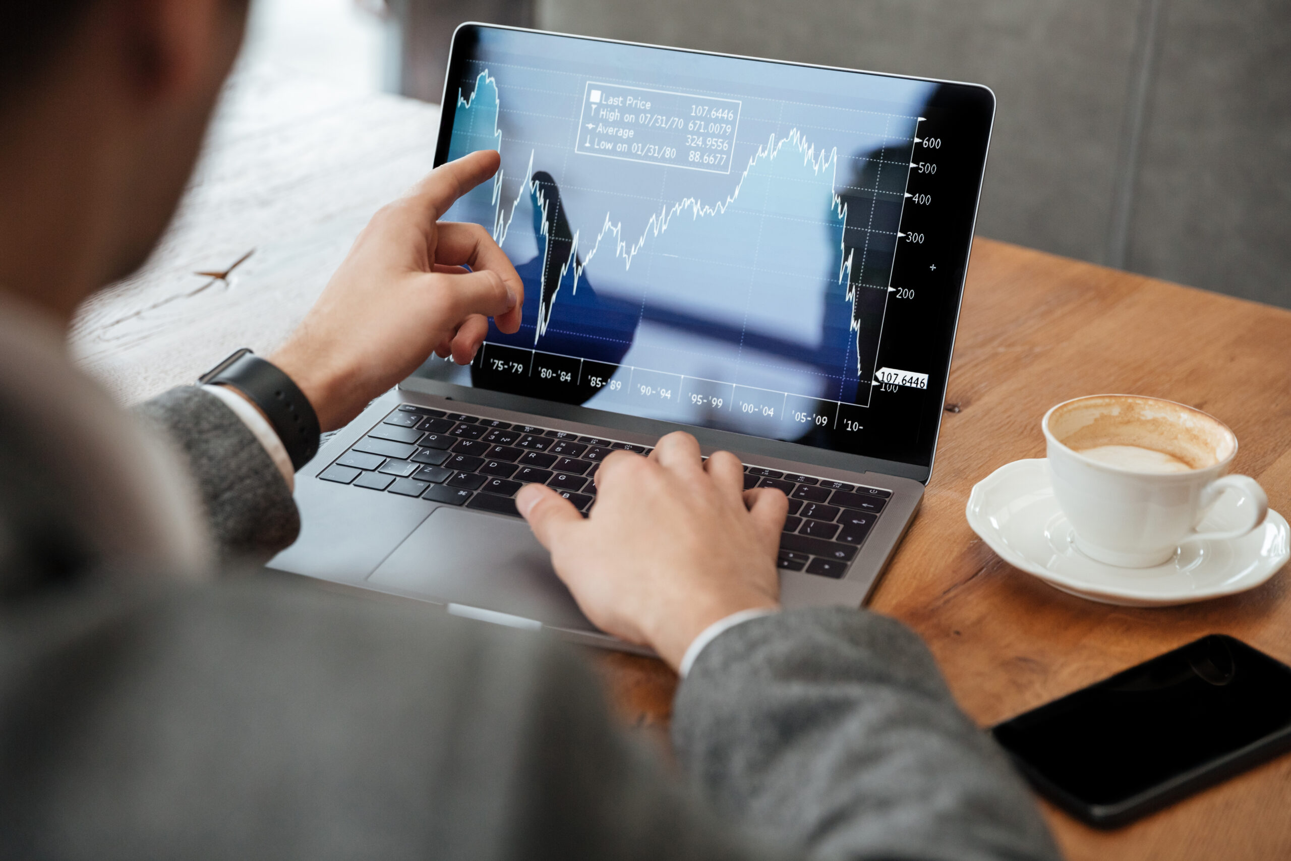 cropped-image-businessman-sitting-by-table-cafe-analyzing-indicators-laptop-computer-scaled-1.jpg